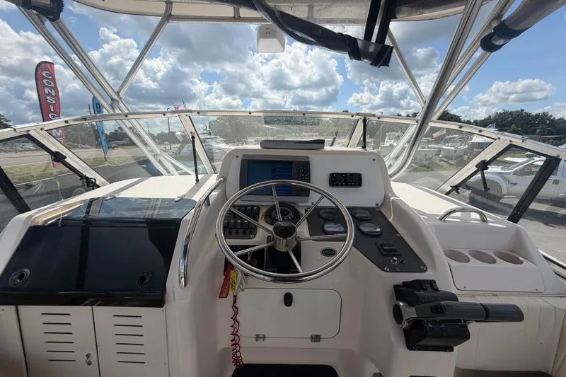 Slide: The Image of Cockpit view of 2000 Grady-White Express 265 boat with steering wheel and navigation instruments. - 43