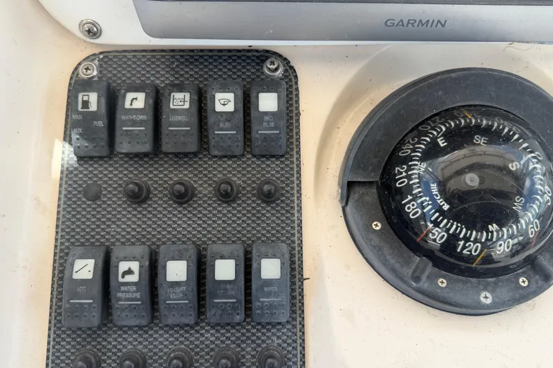 Slide: The Image of Control panel and compass on a 2000 Grady-White Express 265 boat. - 46