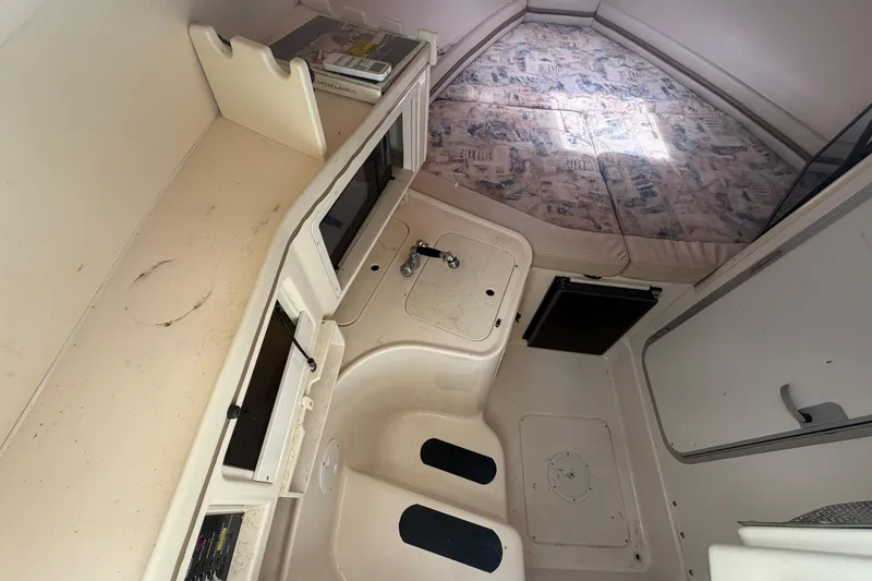 Slide: The Image of 2000 Grady-White Express 265 cabin interior with kitchenette and sleeping area. - 59