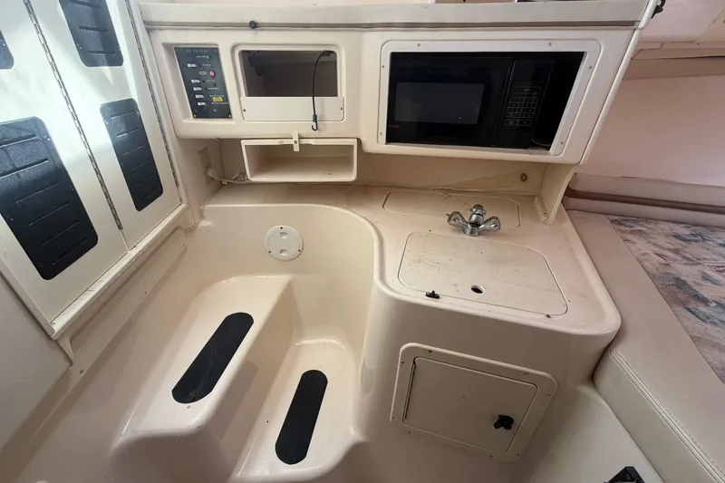 Slide: The Image of 2000 Grady-White Express 265 boat interior with sink, microwave, and control panel. - 61