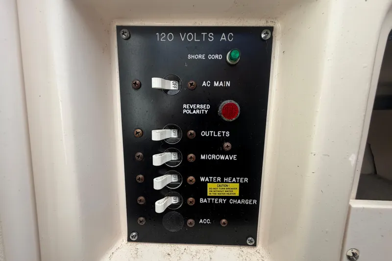 Slide: The Image of Electrical panel on a 2000 Grady-White Express 265 boat, showing AC switches. - 63