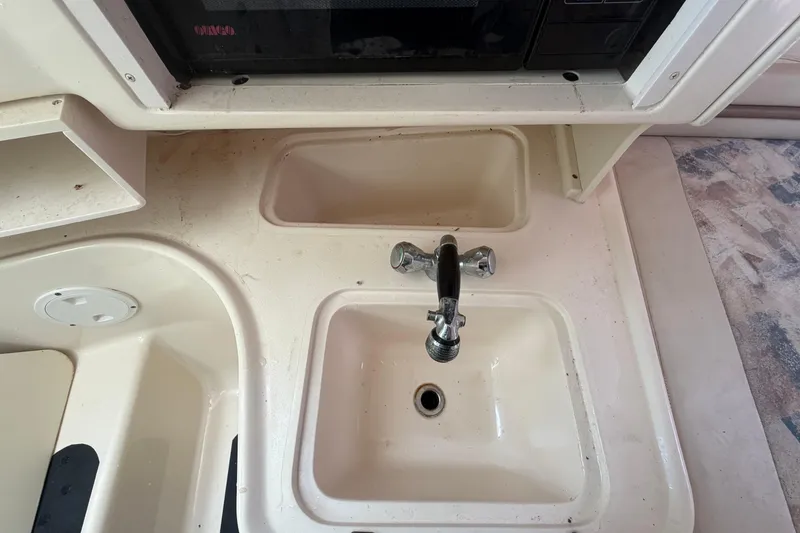 Slide: The Image of Interior view of a 2000 Grady-White Express 265 boat kitchen sink area. - 67