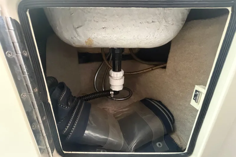 Slide: The Image of Boat compartment interior of a 2000 Grady-White Express 265, showing plumbing and hoses. - 69