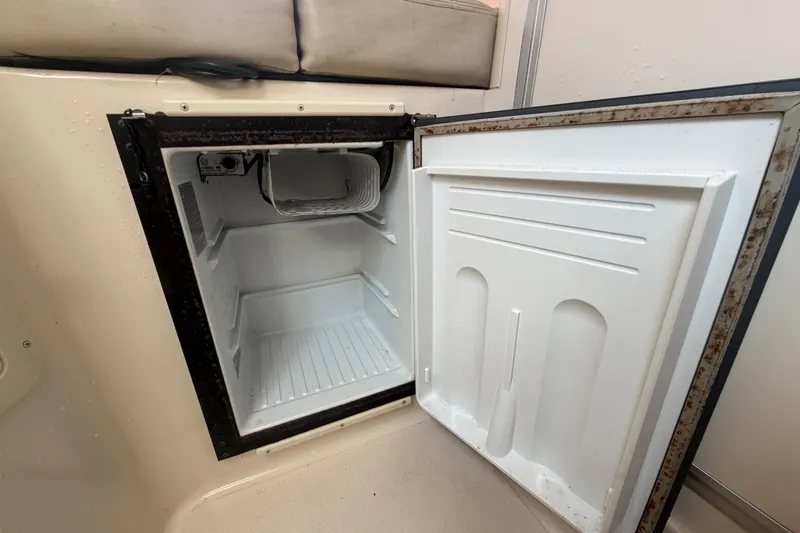 Slide: The Image of Open refrigerator inside a 2000 Grady-White Express 265 boat, showing interior shelves. - 71