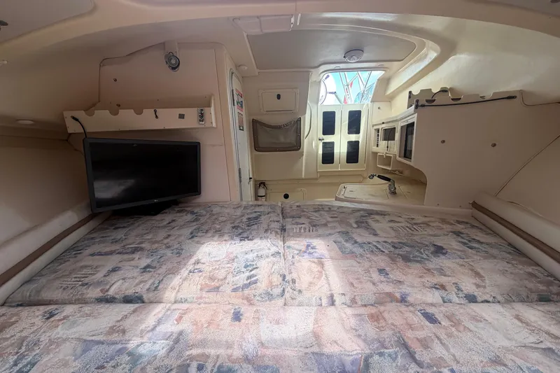 Slide: The Image of Interior cabin of 2000 Grady-White Express 265 boat with bed and TV. - 74