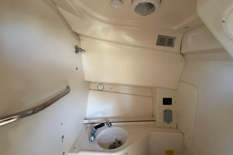 Slide: The Image of Interior of a 2000 Grady-White Express 265 boat, featuring a compact sink area. - 80