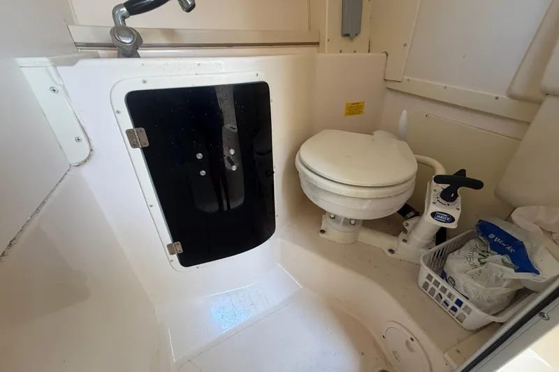 Slide: The Image of 2000 Grady-White Express 265 boat bathroom with toilet and storage basket. - 81