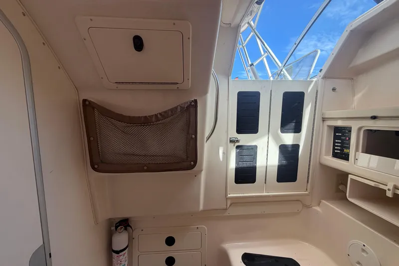 Slide: The Image of Interior view of a 2000 Grady-White Express 265 boat, featuring storage and control panels. - 83