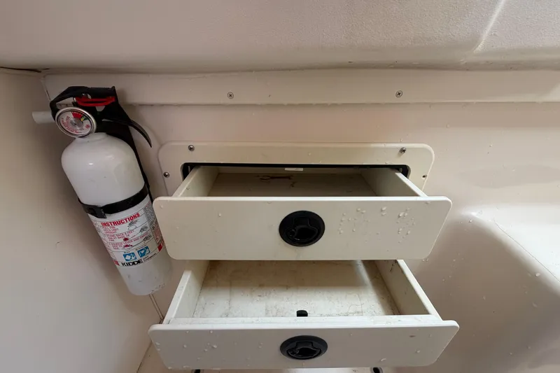 Slide: The Image of Open storage drawers and fire extinguisher on 2000 Grady-White Express 265 boat. - 86