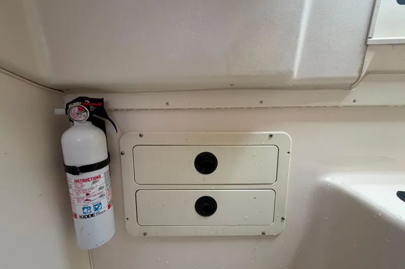 Slide: The Image of Fire extinguisher and storage compartments on 2000 Grady-White Express 265 boat interior. - 87