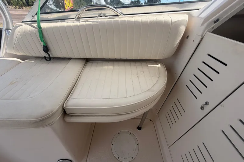Slide: The Image of Interior seating of 2000 Grady-White Express 265 boat, featuring white cushioned seats. - 89