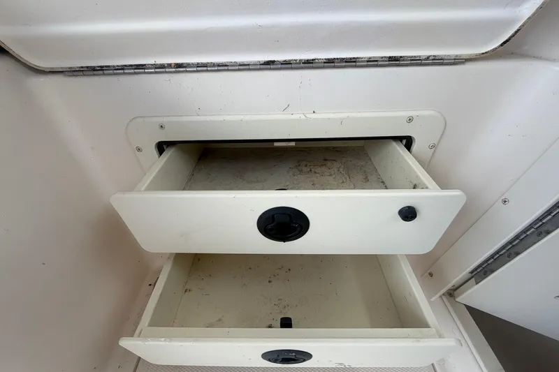 Slide: The Image of Open storage drawers on a 2000 Grady-White Express 265 boat interior. - 91