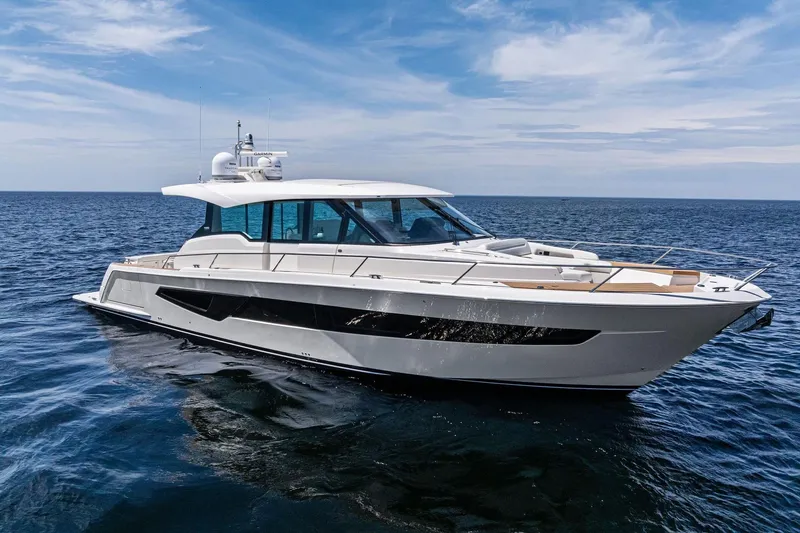 Slide: The Image of 2025 Tiara Yachts EX 60 luxury yacht cruising on open sea under blue sky. - 77