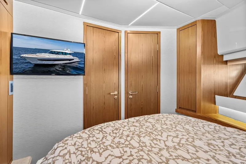 Slide: The Image of Interior of 2025 Tiara Yachts EX 60 with wood accents and wall-mounted TV. - 53