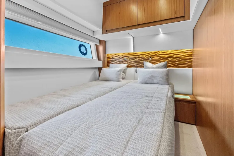 Slide: The Image of Luxurious twin bedroom in 2025 Tiara Yachts EX 60, featuring modern wood accents. - 50