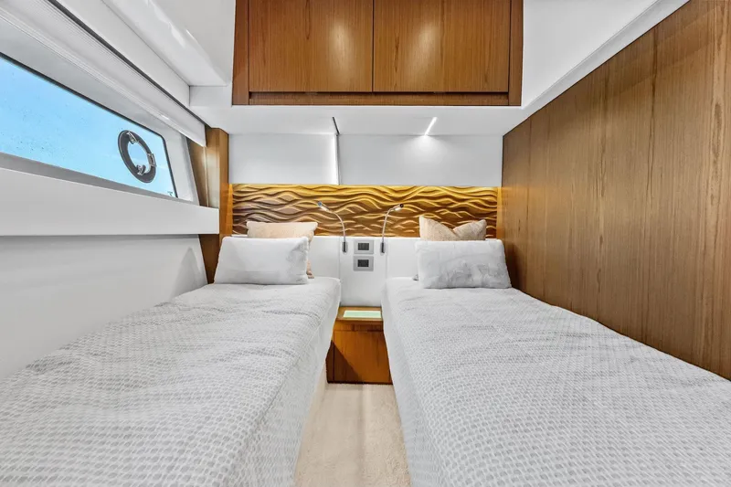 Slide: The Image of Luxurious twin cabin interior of 2025 Tiara Yachts EX 60, featuring elegant wood paneling. - 49