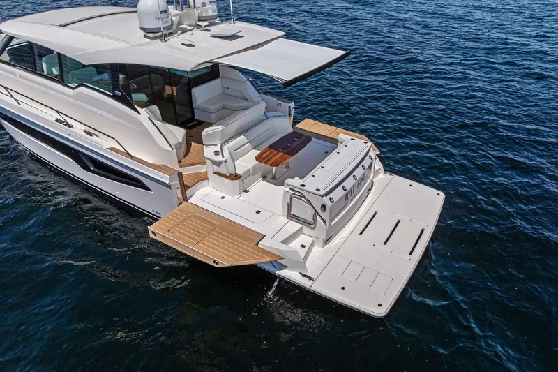 Slide: The Image of 2025 Tiara Yachts EX 60 luxury yacht on open water, featuring spacious deck and modern design. - 54