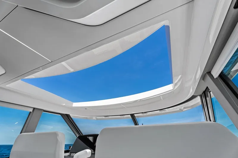 Slide: The Image of Interior view of 2025 Tiara Yachts EX 60 with panoramic sunroof and ocean backdrop. - 76
