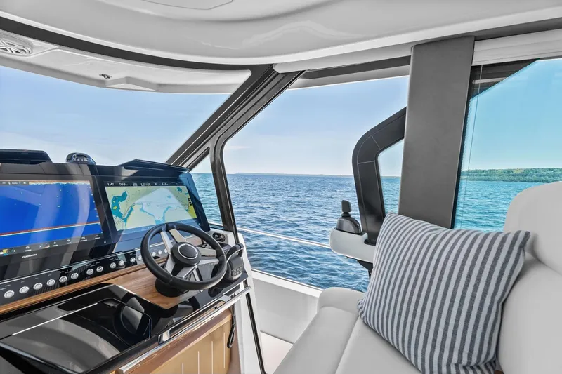 Slide: The Image of Helm of 2025 Tiara Yachts EX 60 with navigation screens and ocean view. - 60