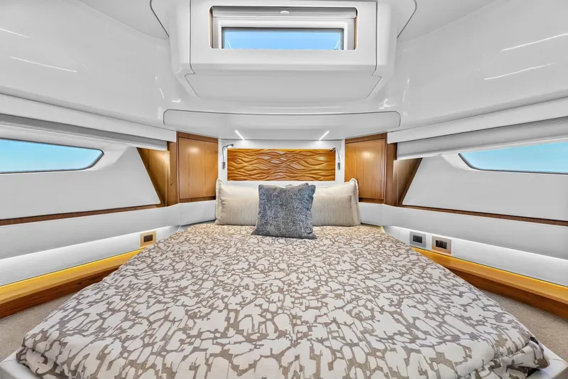 Slide: The Image of Luxurious bedroom interior of 2025 Tiara Yachts EX 60 with elegant bedding and wood accents. - 51