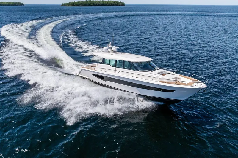 Slide: The Image of 2025 Tiara Yachts EX 60 cruising on open water, leaving a dynamic wake. - 71
