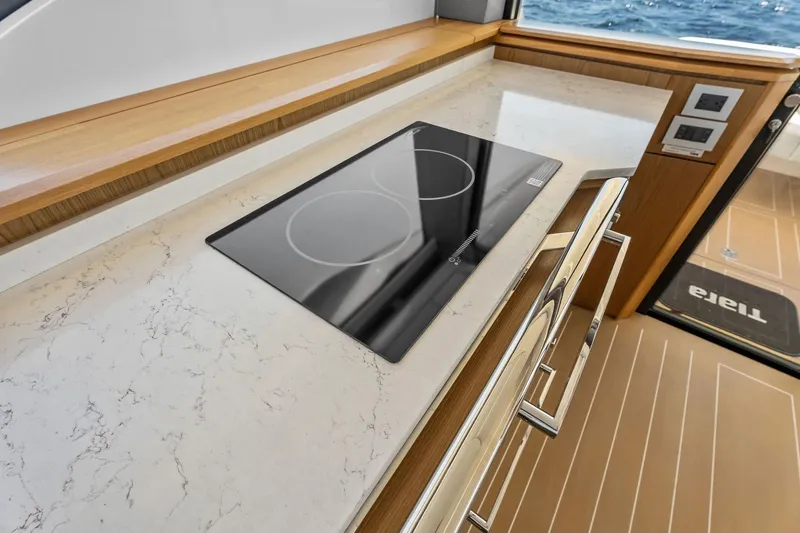 Slide: The Image of Modern kitchen area on 2025 Tiara Yachts EX 60 with sleek induction cooktop. - 63