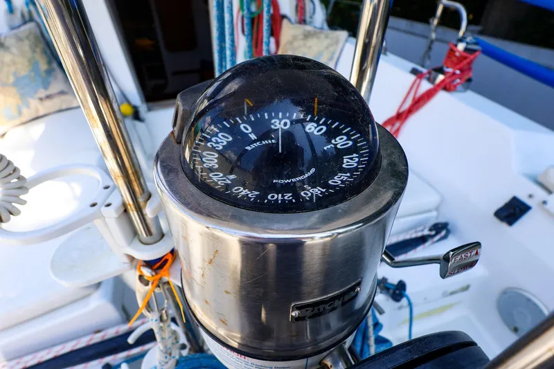 Slide: The Image of Compass on a 2001 J Boats J/32 sailboat cockpit, featuring nautical ropes and controls. - 8