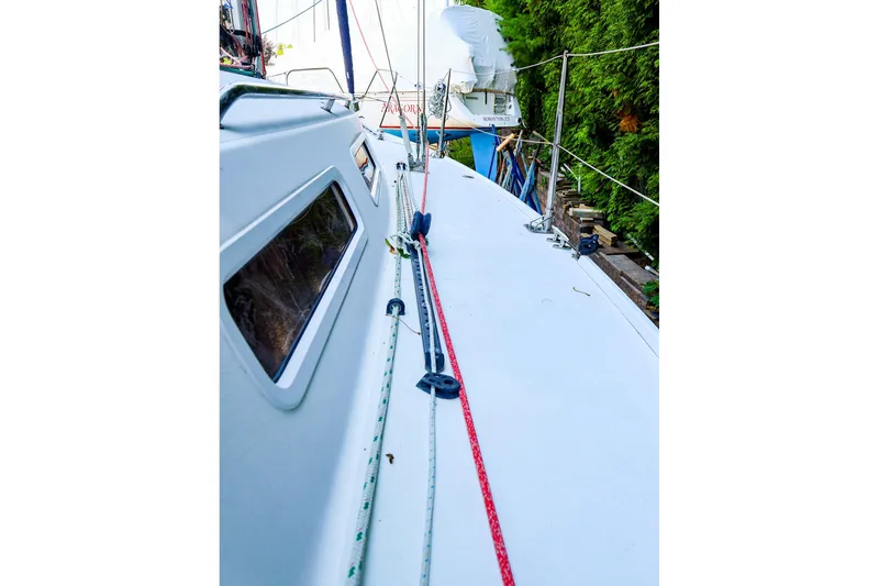 Slide: The Image of 2001 J Boats J/32 sailboat deck with rigging and lush greenery background. - 18