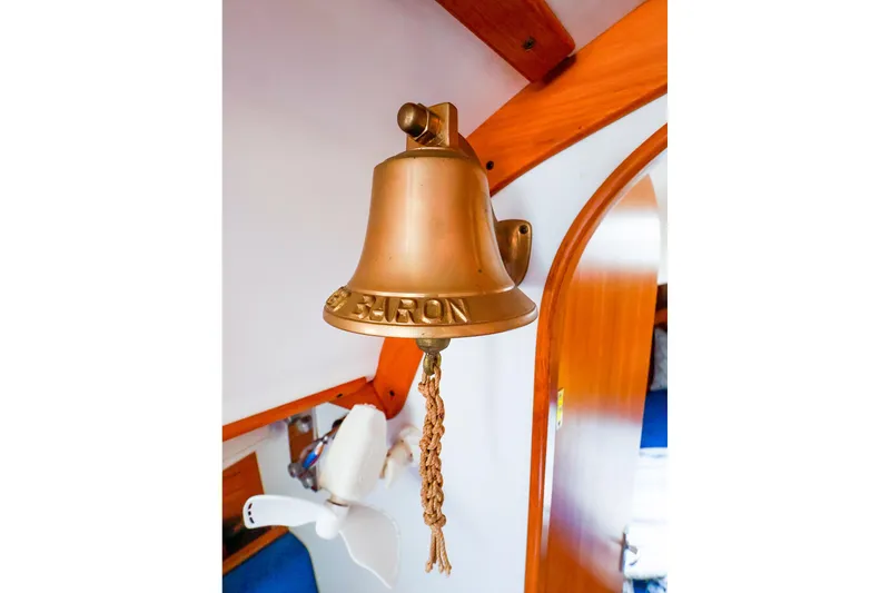 Slide: The Image of Brass bell inside 2001 J Boats J/32 sailboat, featuring wooden interior accents. - 39