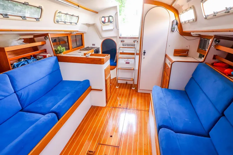 Slide: The Image of Interior of 2001 J Boats J/32 sailboat with blue seating and wooden flooring. - 27