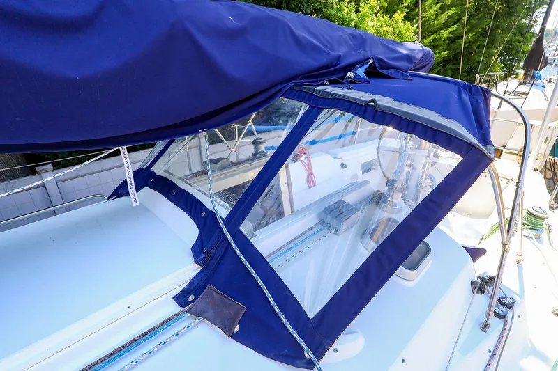 Slide: The Image of 2001 J Boats J/32 sailboat with blue canvas cover and clear windows. - 13