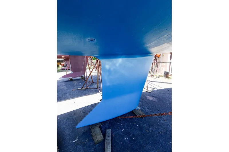 Slide: The Image of 2001 J Boats J/32 sailboat keel in dry dock, showcasing blue hull and rudder. - 3