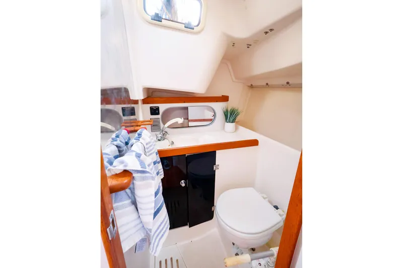 Slide: The Image of 2001 J Boats J/32 yacht bathroom with sink, toilet, mirror, and striped towel. - 43