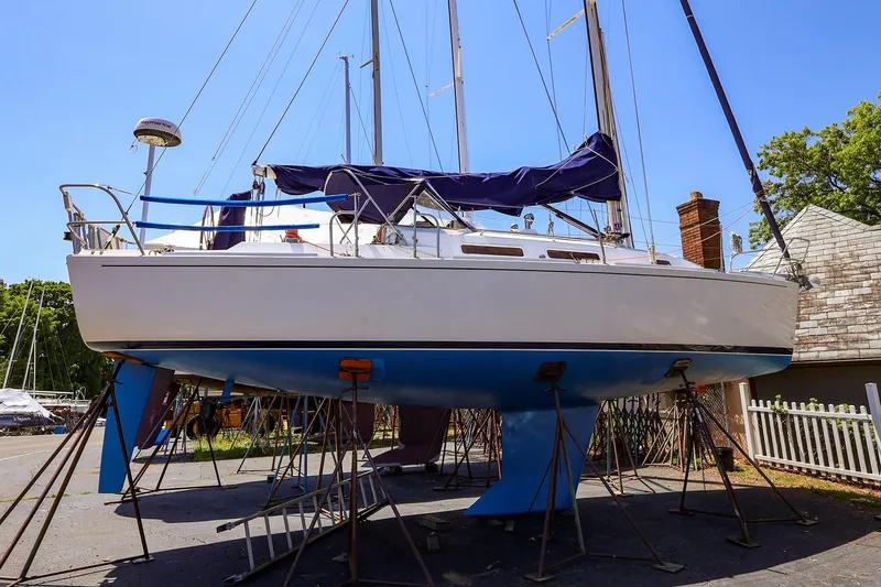 Slide: The Image of 2001 J Boats J/32 sailboat on stands, blue hull, outdoor setting. - 47