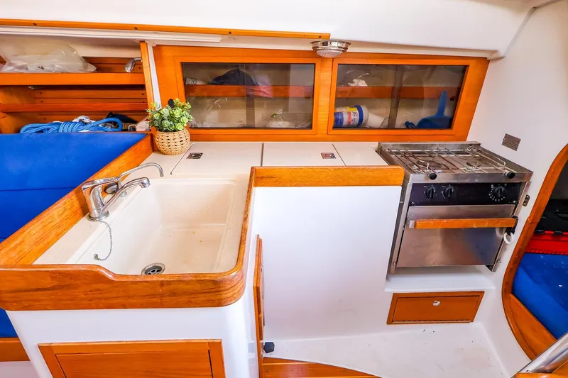 Slide: The Image of 2001 J Boats J/32 yacht interior with kitchen sink, stove, and wooden cabinetry. - 31