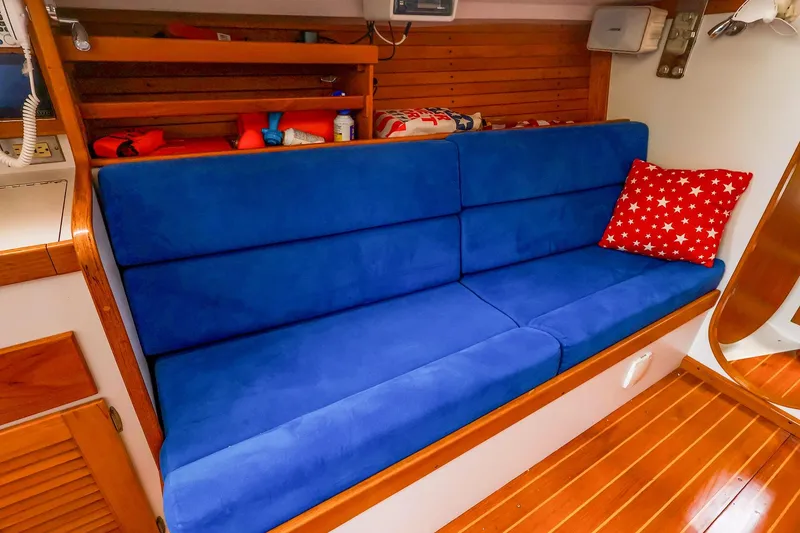 Slide: The Image of Interior of 2001 J Boats J/32 with blue seating and star-patterned pillow. - 29