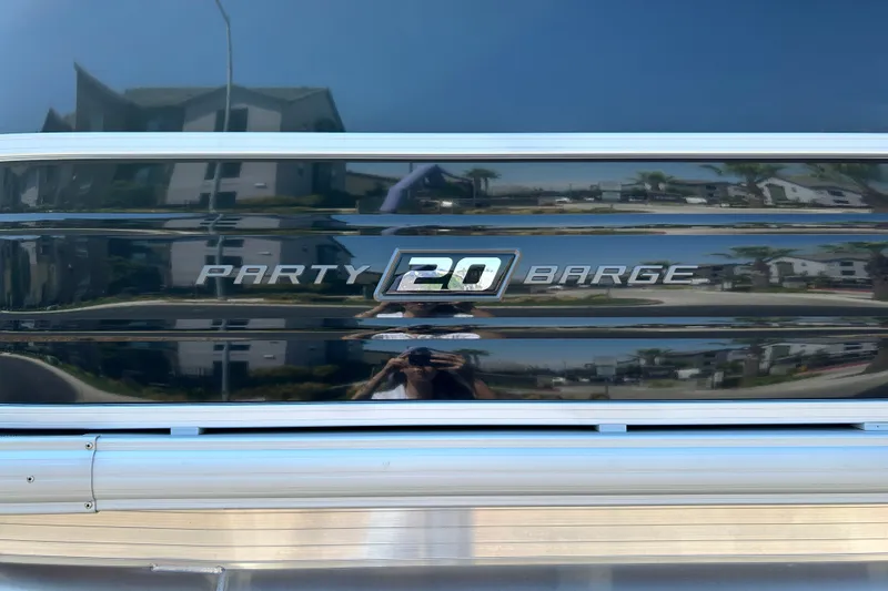 Slide: The Image of 2026 Sun Tracker Party Barge 20 DLX logo on reflective surface. - 22