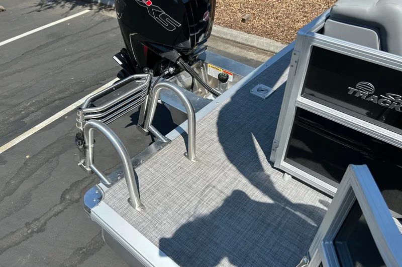 Slide: The Image of 2026 Sun Tracker Party Barge 20 DLX pontoon boat with ladder and motor detail. - 16