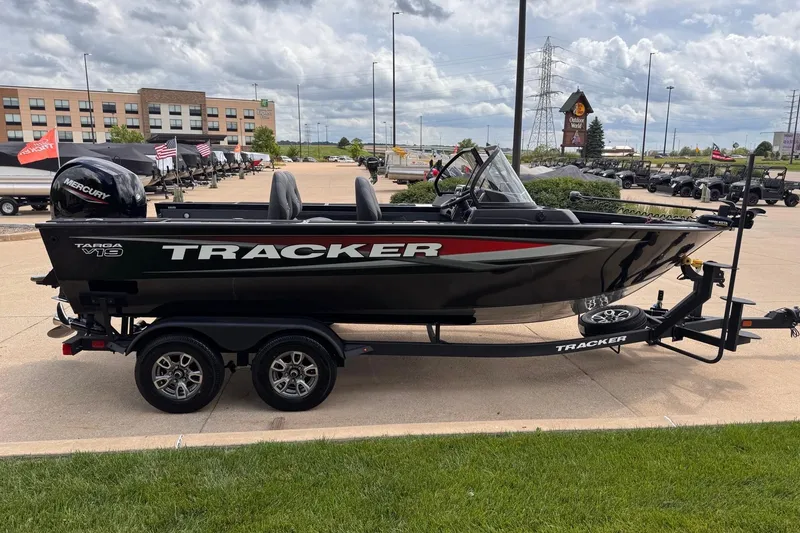 Slide: The Image of 2026 Tracker Targa V-19 WT boat on trailer, parked outdoors under cloudy sky. - 2