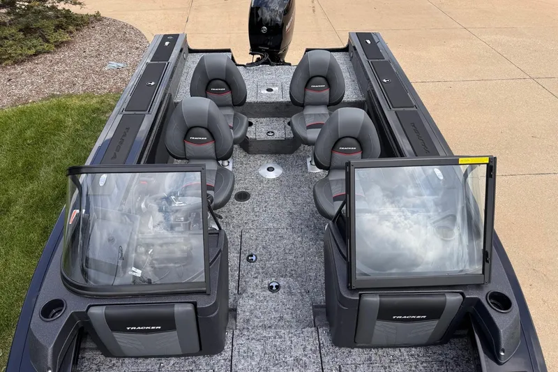 Slide: The Image of 2026 Tracker Targa V-19 WT boat interior with seating and windshield, parked on pavement. - 5