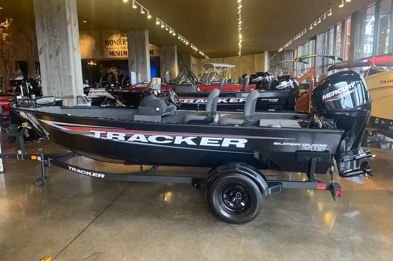 The Image of 2026 Tracker Super Guide V-16 SC boat displayed in a showroom with Mercury engine. - 0