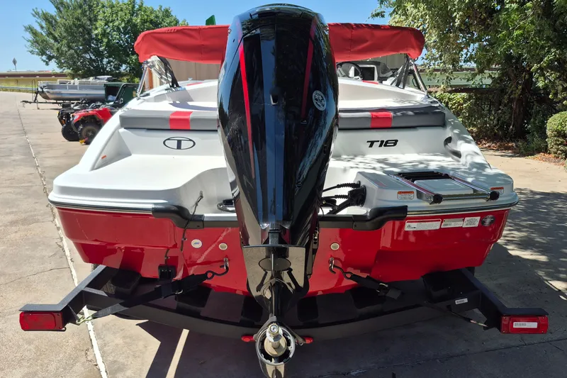 Slide: The Image of 2026 Tahoe T18 boat with red and white design, parked outdoors, featuring a powerful outboard motor. - 6