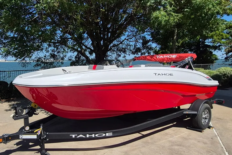 Slide: The Image of 2026 Tahoe T18 boat in vibrant red on a trailer by a lakeside. - 1