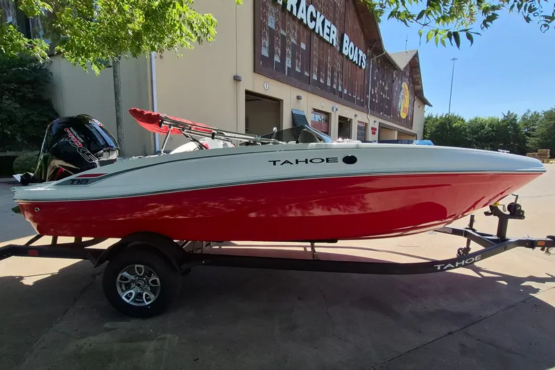 Slide: The Image of 2026 Tahoe T18 boat with red and white design on a trailer outside a building. - 4