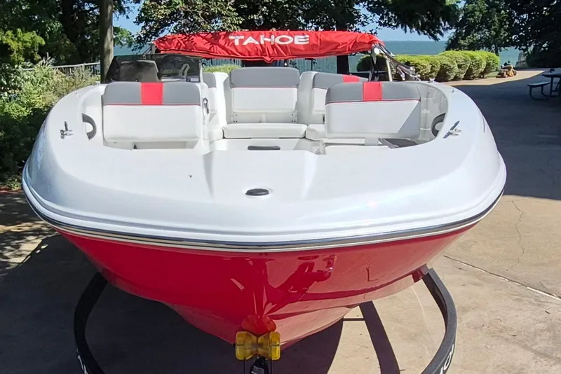 Slide: The Image of 2026 Tahoe T18 boat with red and white design, parked outdoors. - 2