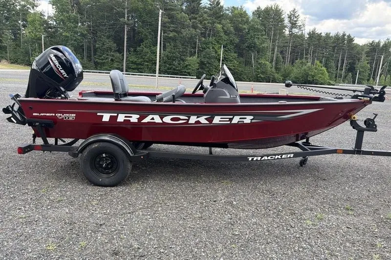 Slide: The Image of 2026 Tracker Super Guide V-16 SC boat on trailer, red color, parked outdoors. - 2