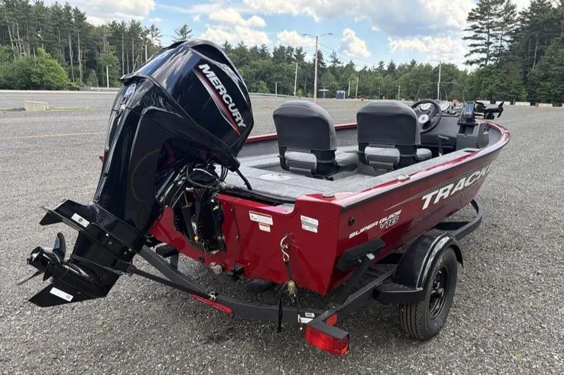 Slide: The Image of 2026 Tracker Super Guide V-16 SC boat with Mercury engine in a parking lot. - 5