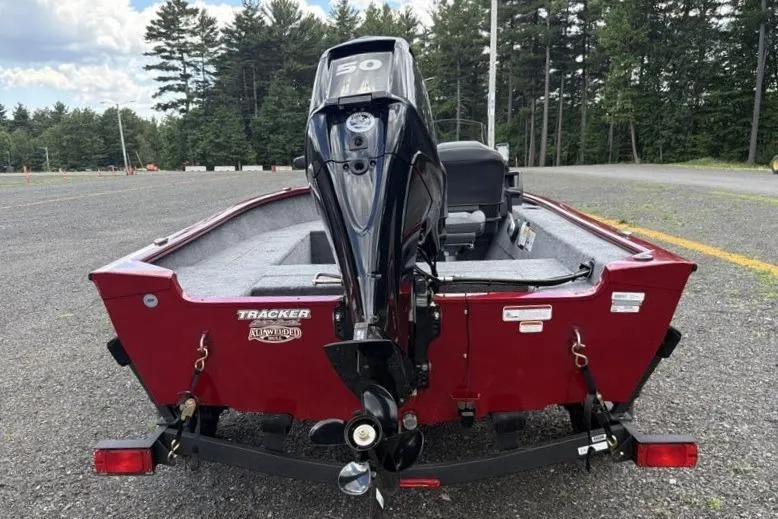 Slide: The Image of 2026 Tracker Super Guide V-16 SC boat with outboard motor, parked outdoors. - 8
