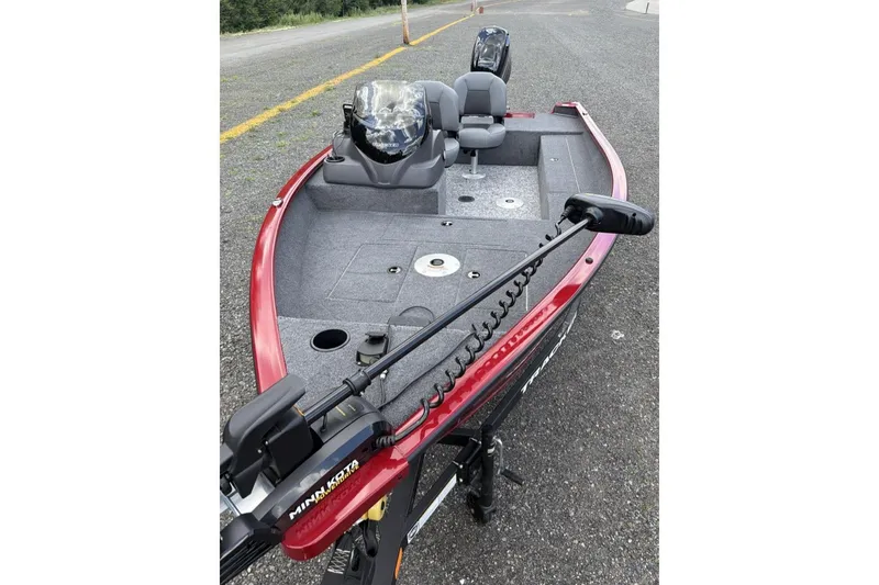 Slide: The Image of 2026 Tracker Super Guide V-16 SC boat with red exterior and gray interior on a road. - 6