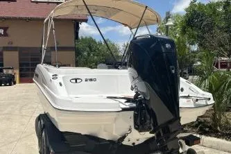Slide: The Image of 2026 Tahoe 2150 boat with canopy and outboard motor in sunny outdoor setting. - 7